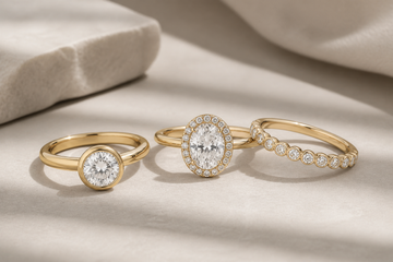 Three lab grown diamond rings for everyday wear, including a round bezel solitaire, an oval halo ring, and a slim diamond band.