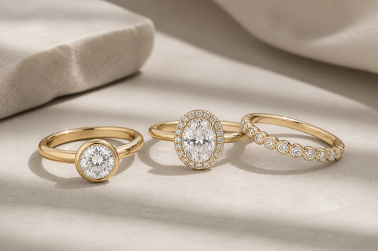 Three lab grown diamond rings for everyday wear, including a round bezel solitaire, an oval halo ring, and a slim diamond band.