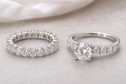 Diamond eternity band next to an engagement ring on a neutral surface