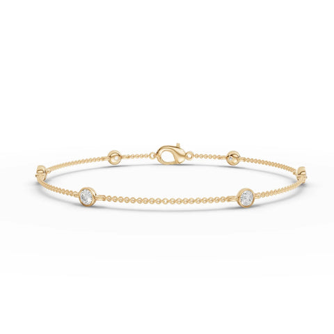 Refined 0.60 Ct round bezel lab diamond bracelet in 18k gold, featuring polished bead links and a secure lobster clasp.