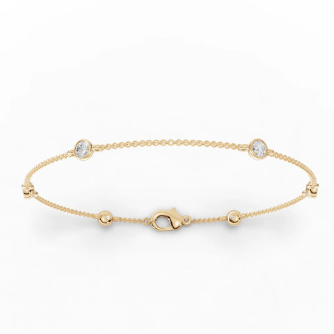 18k gold bracelet featuring three round bezel-set lab grown diamonds and polished bead stations for a delicate, balanced design.