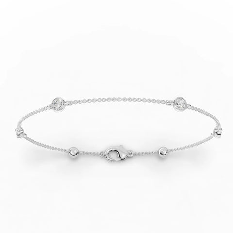 Delicate 0.60 Ct round bezel lab diamond bracelet in 18k gold, featuring polished bead links and a lobster clasp.