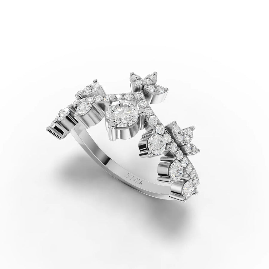 Crown style lab diamond ring featuring a round center stone and accent diamonds arranged in floral motifs. Silver band.
