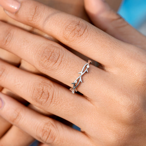 1.06 Ct solitaire ring featuring a round center diamond with intertwined floral-inspired bands and accent diamonds set in white gold.