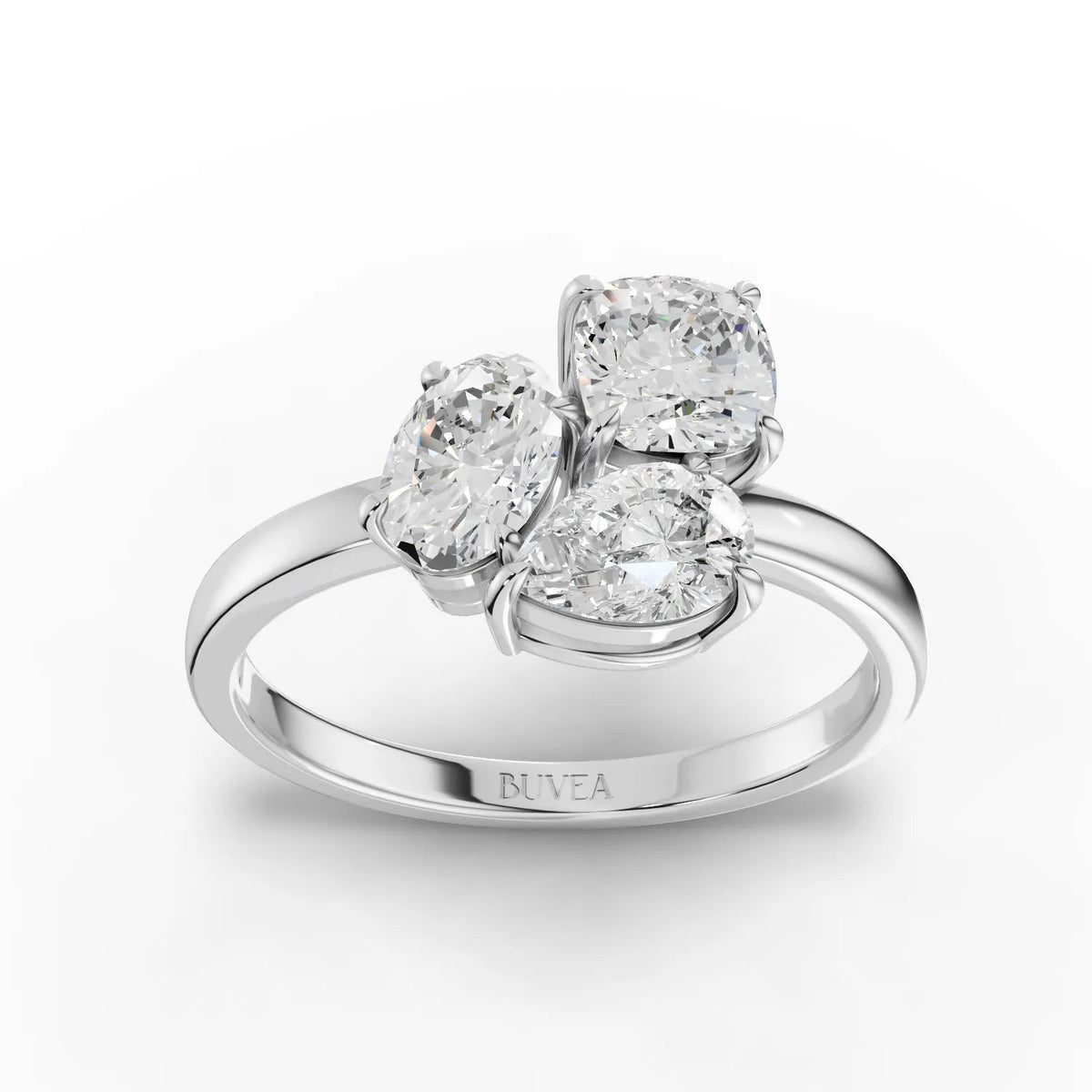 Three stone lab grown diamond ring featuring an oval center stone, cushion-cut, and pear-shaped side stones, set in 18K gold.