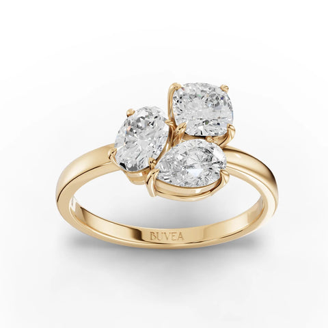 Three-stone lab grown diamond ring featuring an oval center, cushion-cut, and pear-shaped diamonds set in 18K gold.