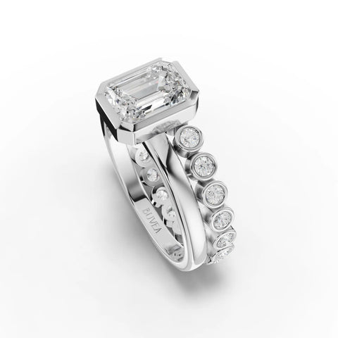 Emerald-cut lab-grown diamond ring in a bezel setting, accented by round diamonds on a sleek band.