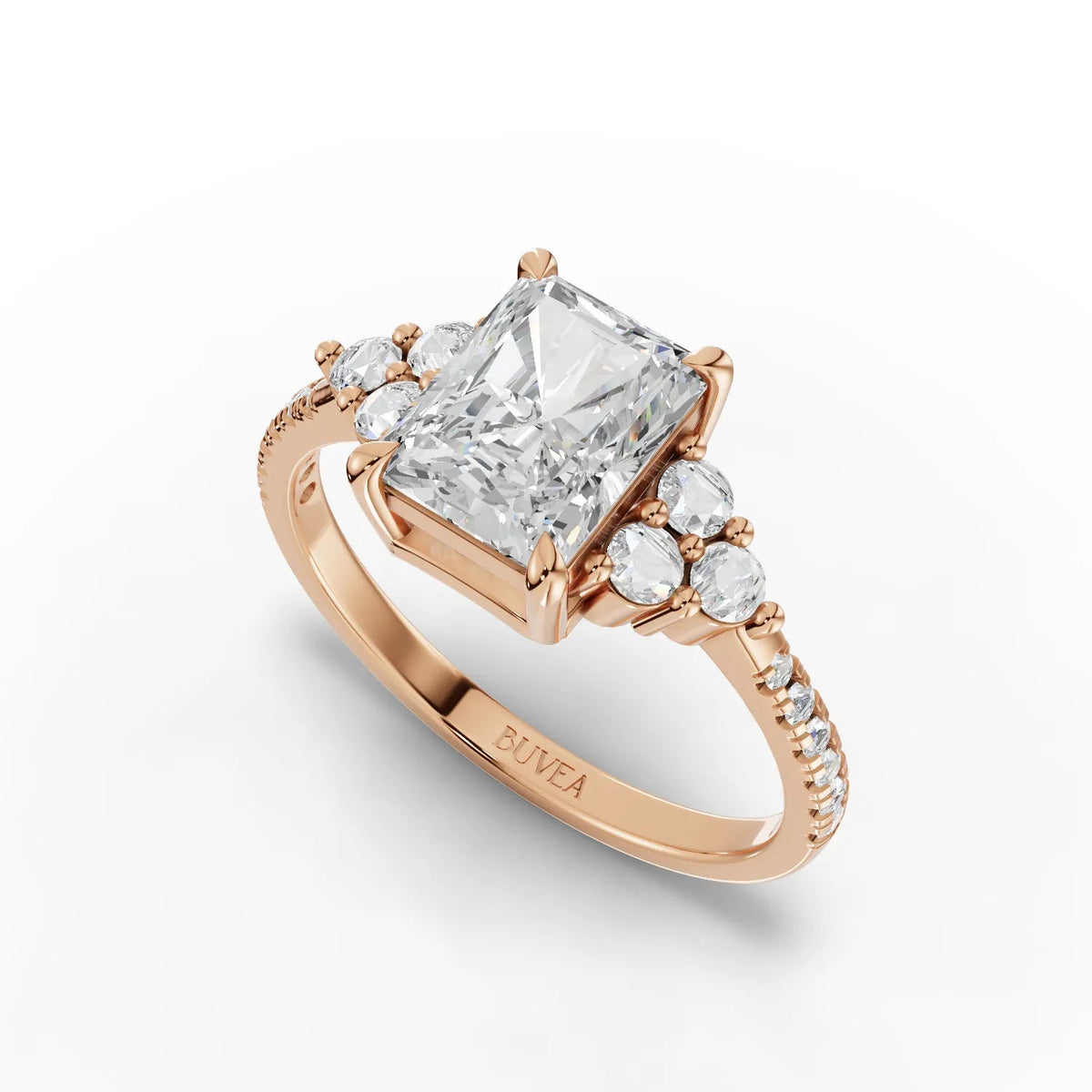 A radiant-cut lab grown diamond center stone is set in rose gold, surrounded by a halo of round accent diamonds.