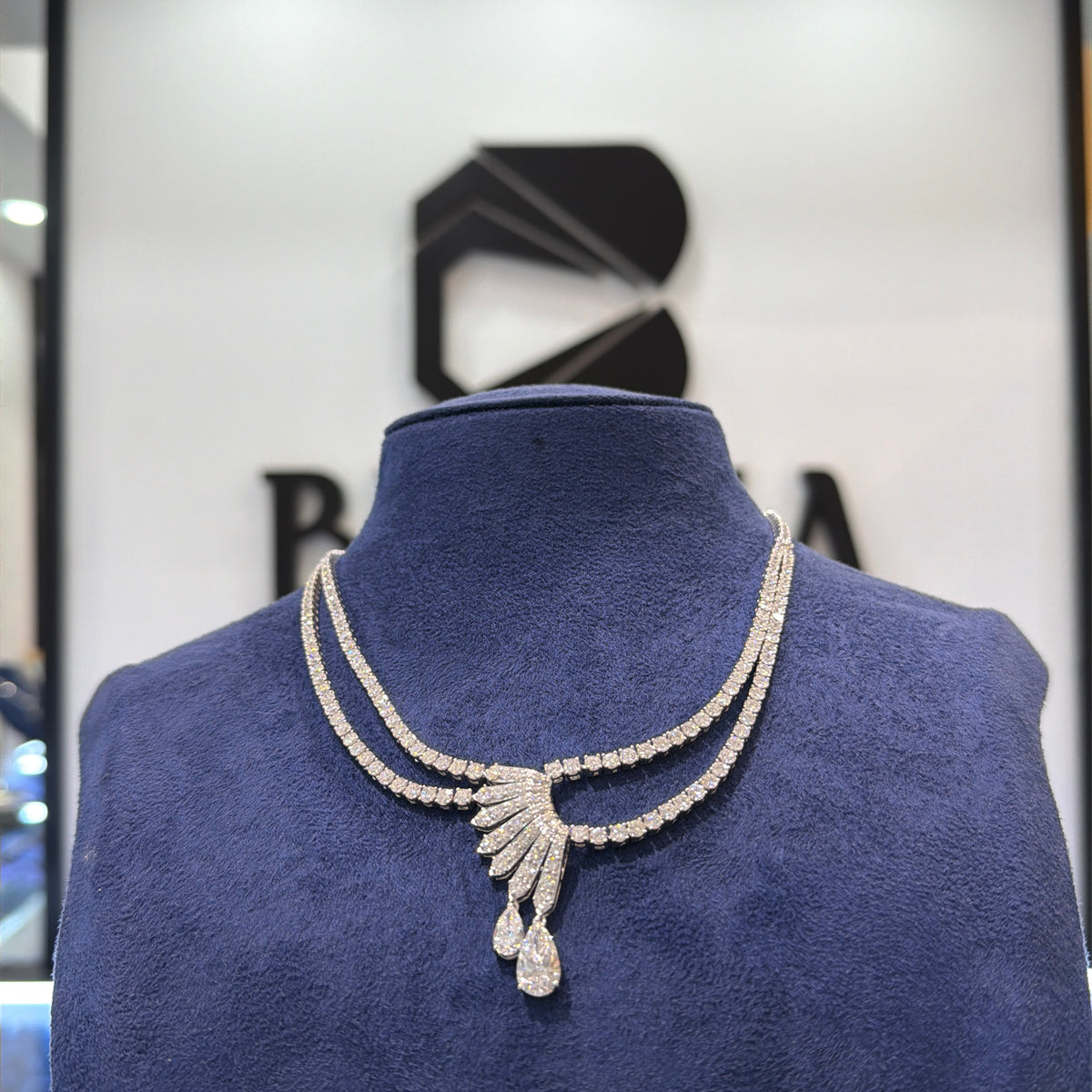 قلادة مزدوجة الصفوف مرصعة بألماس صناعي مع تصميم مركزي على شكل مروحة وتفاصيل على شكل قطرة كمثرى