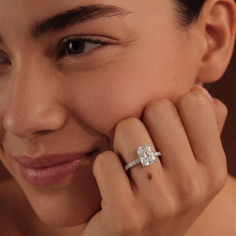 Radiant cut lab diamond ring featuring a 1 CT center stone with round accent diamonds, set in an elegant 18K gold band.