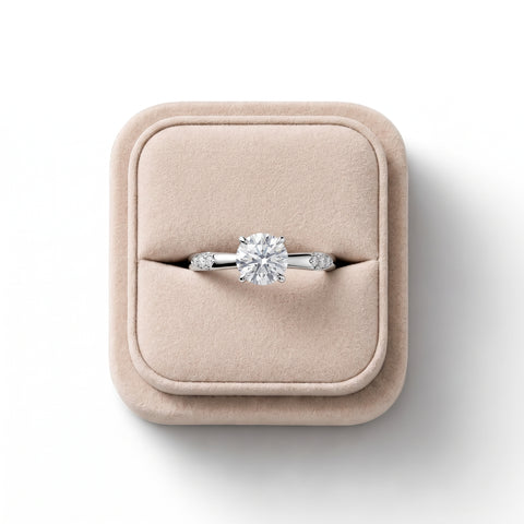 Round solitaire ring featuring a 1 CT lab-grown diamond in a four-prong setting with three accent diamonds on either side.