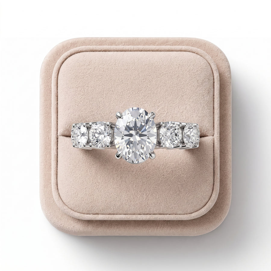 Oval solitaire ring featuring a 1 CT diamond center and round accent diamonds, set in a refined 18K gold band.