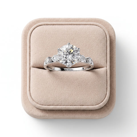 Round solitaire ring featuring a 1.50 Ct center diamond with symmetrical side diamonds, set in polished white gold.