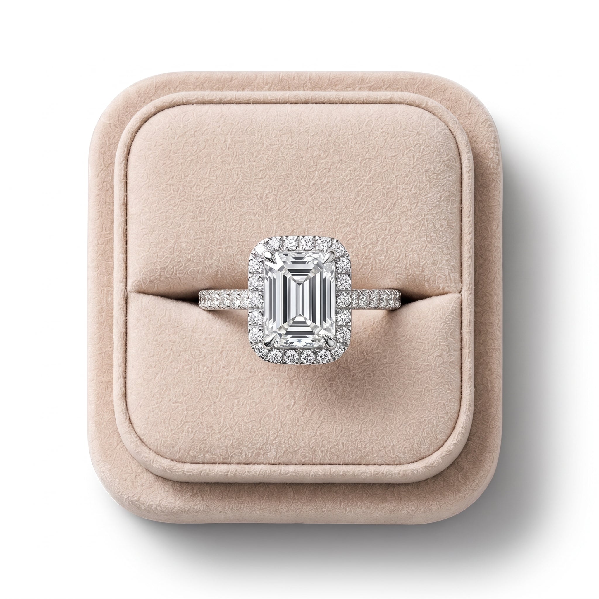 Emerald cut lab grown diamond ring with a round diamond halo, set in an 18K gold band, showcased on a soft display.