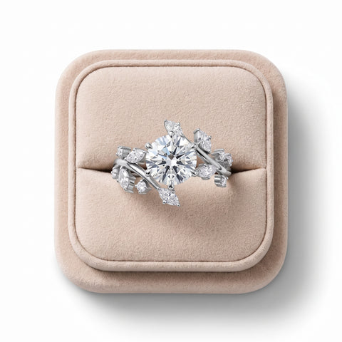 Round solitaire ring featuring a 2 CT lab grown diamond center, accented by marquise and round diamonds, set in 18K gold.