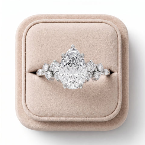 1.70 CT pear-shaped lab diamond ring featuring round side accents, elegantly displayed on a soft-colored jewelry box.