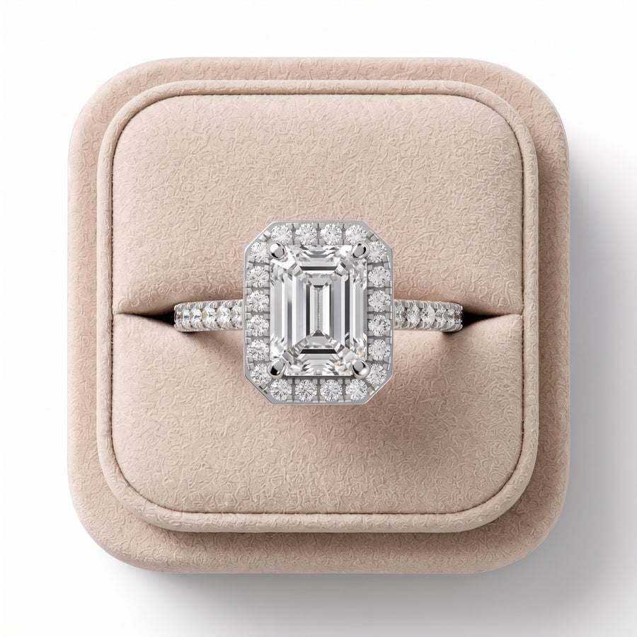 2.34 CT emerald cut lab diamond ring with a pavé band, featuring a halo of round diamonds and a polished silver setting.