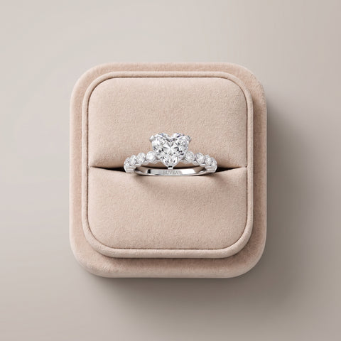 Heart-shaped lab diamond ring with a 2.77 ct total weight, set in an 18K gold band with round accent diamonds on each side.