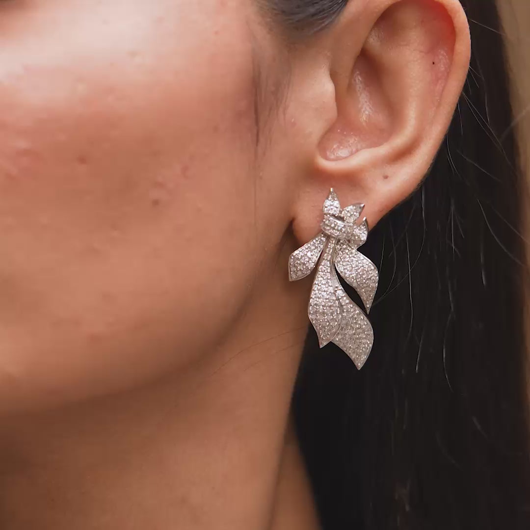 Earrings in motion highlighting curved design on model